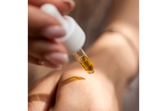 Image A person putting oil on their hand.